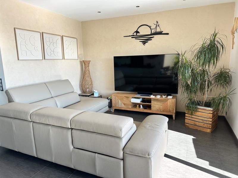 Salon cosy, cuir clair et écran géant